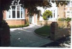 AFTER: Driveway constructed using Tegula paving with sweeping curved path to front door and feature band across drive mouth, new wall, lawn and planting installed.