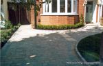 AFTER: Driveway constructed using Tegula paving with sweeping curved path to front door and feature band across drive mouth, new wall, lawn and planting installed.