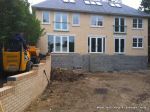 Stepped retaining Concrete block wall with added rebar and concrete for strength and facing brick to finish