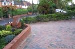 Stepped red brick wall with built in bin cupboard 