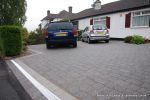 New driveway installed using granite paving with contrasting colour band and inset lights