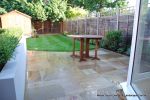 patio was constructed useing fossil sandstone in 4 sizes laid to a random pattern with a curved block planter wall painted in gun ship grey and planted with a topiary hedge.