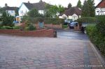 Stepped red brick wall with built in bin cupboard 