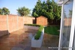 patio was constructed useing fossil sandstone in 4 sizes laid to a random pattern with a curved block planter wall painted in gun ship grey and planted with a topiary hedge.