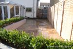 patio was constructed useing fossil sandstone in 4 sizes laid to a random pattern with a curved block planter wall painted in gun ship grey and planted with a topiary hedge.