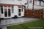 AFTER: New Granite patio and path installed with contrasting dark coulour band, New lawn, fencing and planting installed