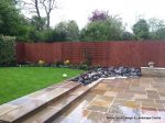 Patio installed with 4 size sawn sandstone paving edged with firestone rocks and alpine planting, steps built with sawn sandstone uprights and sawn sandstone bullnose treads