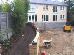 Stepped retaining Concrete block wall with added rebar and concrete for strength and facing brick to finish