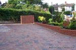 Stepped red brick wall with built in bin cupboard 