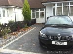 New driveway installed using granite paving with contrasting colour band and inset lights