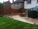 Tired garden received a complete new design Patio installed with 4 size sawn sandstone paving edged with firestone rocks and alpine planting, steps built with sawn sandstone uprights and sawn sandstone bullnose treads, New lawn installed in 3 rings all ed