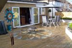 Soft wood decking with sandstone sunflower circle feature incorporated into the centre 