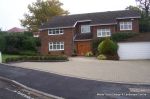 Driveway constructed using pewter grey paving with contrasting colour band and feature curved double row of kerbs with Topiary hedge to retain level change & inset LED lights