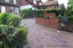 Stepped red brick wall with built in bin cupboard 