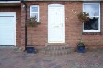 Driveway installed with Tegula paving laid at 45 degree to property with in set lighting and feature wall merging into timber wall along front garden and road boundary